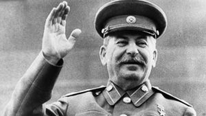 A smiling General Joseph V. Stalin raises his right hand in salute while reviewing a May Day Parade, in Moscow, May 1, 1946. Photo from Russian film. (AP Photo)