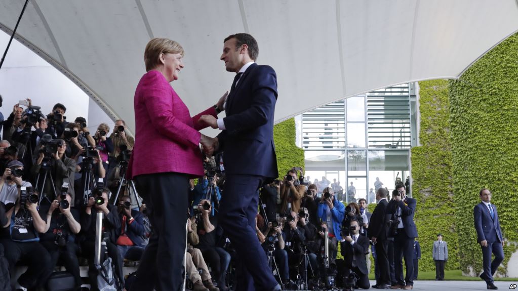 New French President Emmanuel Macron is welcomed by German Chancellor Angela Merkel in Berlin Monday, May 15, 2017, during his first foreign trip after his inauguration the day before. (AP Photo/Michael Sohn)