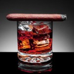 Lit Cigar resting on Glass of Whiskey and Ice cubes