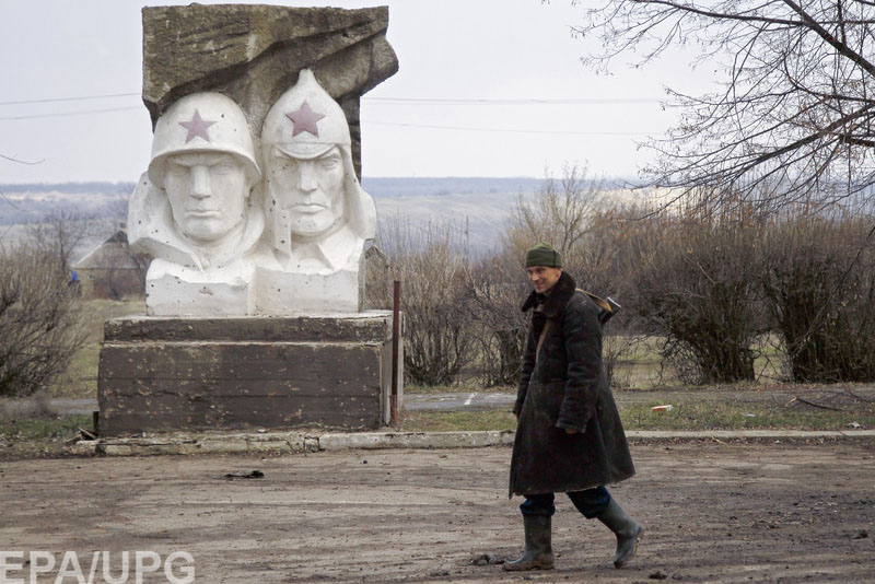 epa05227540 A pro-Russian militant walks past a monument of former Soviet Union time near of frontline in Zaytseve village of Donetsk area, Ukraine, 23 March 2016. The pro-Russian rebels forces attacked Ukrainian army positions in eastern Ukraine 44 times in the past 24 hours, violating the Minsk agreements and using banned weapons, according to press center of the Anti-Terrorist Operation report.  EPA/ALEXANDER ERMOCHENKO